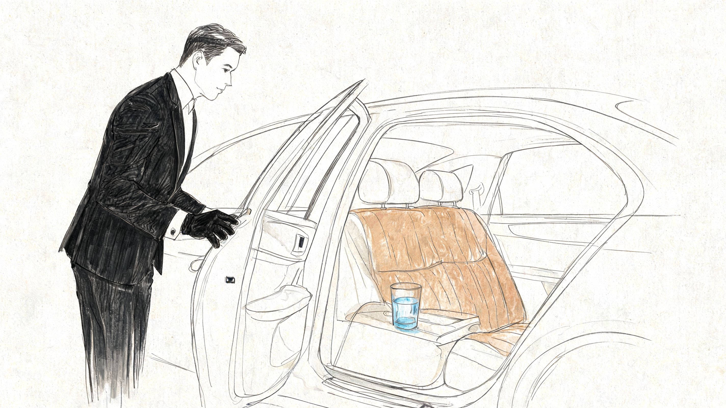 A professional chauffeur in a suit holds open the back door of a luxury car.